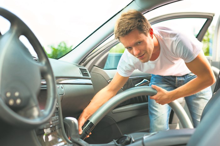 Мужчина пылесосит салон авто